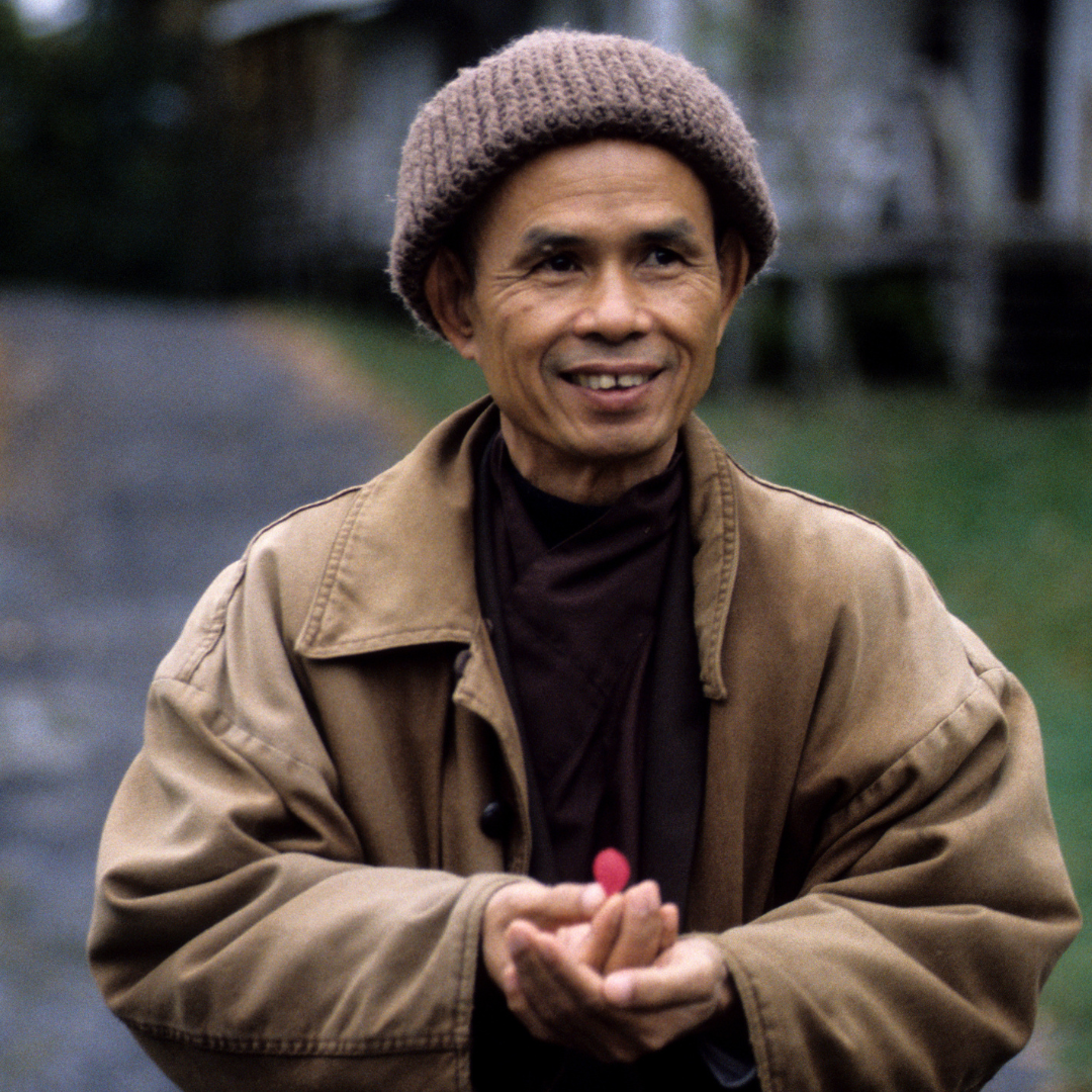 Picture of Thich Nhat Hanh holding a delicate flower petal.