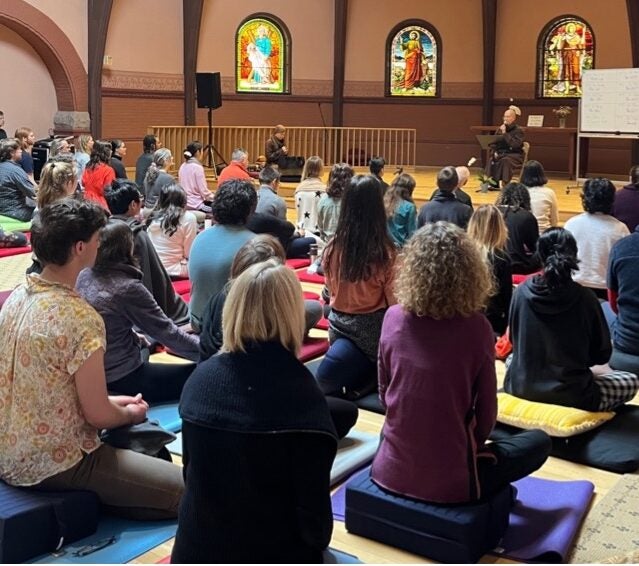 participants sitting in a room at listening to a dharma talk